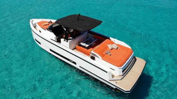 The aft deck of motor yacht Ikigai features comfortable seating areas and sun loungers.