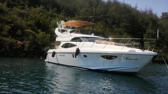 The motor yacht İmera is anchored in a tranquil bay.