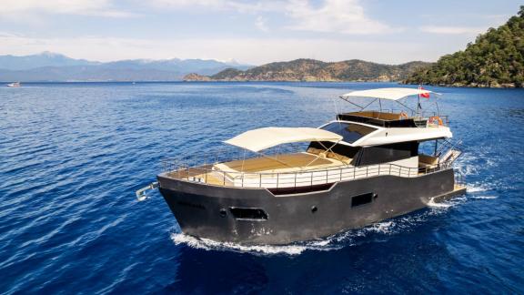 Motor yacht Imperial, cruising in blue waters, enchants with its natural beauty.