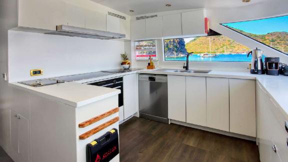 The kitchen of motor yacht Julem 1 is modern, fully equipped, and offers a sea view.