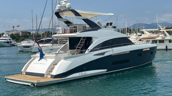 Die Motoryacht Just the two of Us bietet eine große Badeplattform und einen modernen Flybridge Bereich in der Marina von