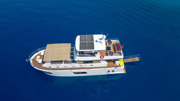 The trawler yacht Kaan Bey 2 is peacefully anchored in open blue waters.