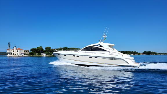 Motoryacht Katrin fährt schnell durch das blaue Meer, im Hintergrund eine Insel.