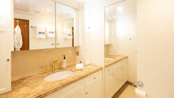 Kokomo Nights features a stylish guest bathroom with large mirrors and a marble vanity countertop.