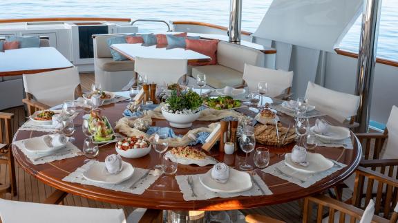 Kokomo Nights offers an inviting upper deck dining area with panoramic sea views while cruising from Athens.
