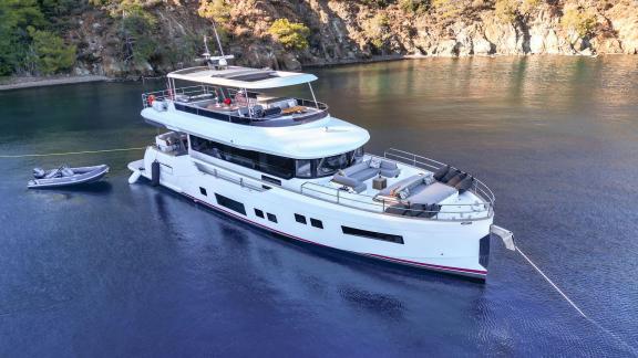 La Luna motor yacht is anchored in a calm bay, enjoying a peaceful moment.