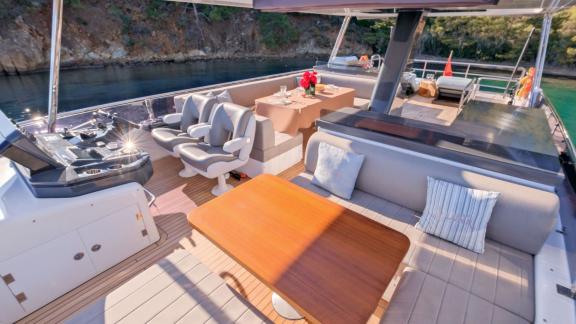 The flybridge of motor yacht La Luna features a comfortable seating area and a dining table.