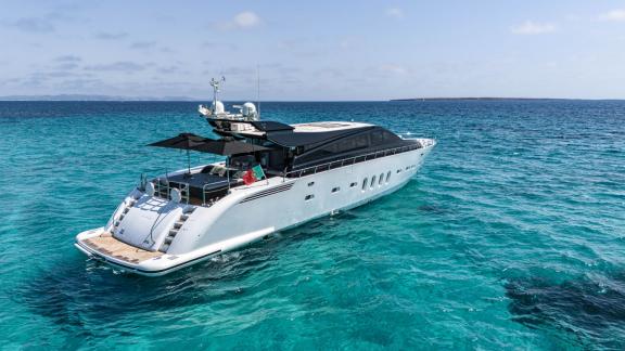 The motor yacht La Romana is anchored in calm turquoise waters of the open sea.