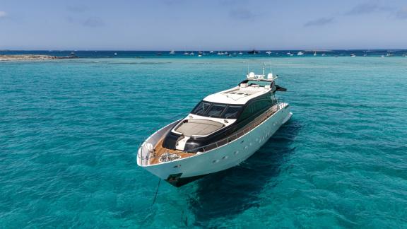 The motor yacht La Romana is peacefully anchored in clear turquoise waters.