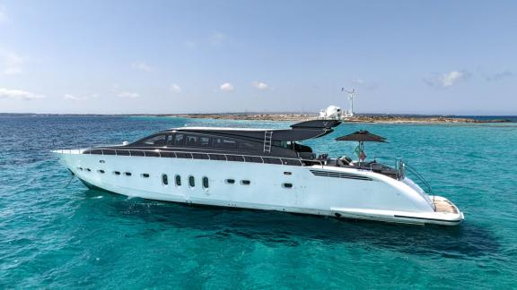 The motor yacht La Romana is anchored in crystal-clear turquoise waters.