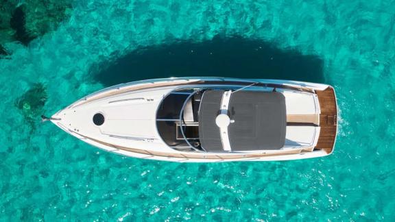 The Lady Boss motor yacht is seen from above, floating in crystal-clear blue waters with all details visible.