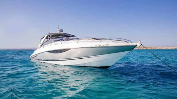 The Lady Boss motor yacht is anchored in calm blue waters, resting peacefully.