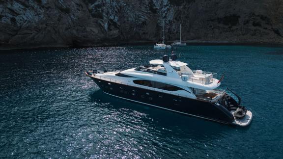 Among Ibiza weekly yacht charter options, Lady KC is seen anchored in a sheltered bay.