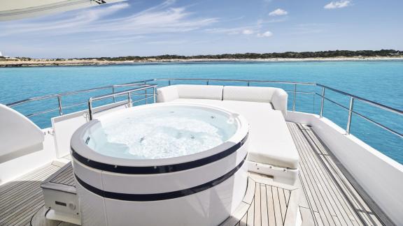 The aft deck of Lady KC with a jacuzzi offers the perfect spot to relax against the turquoise sea.