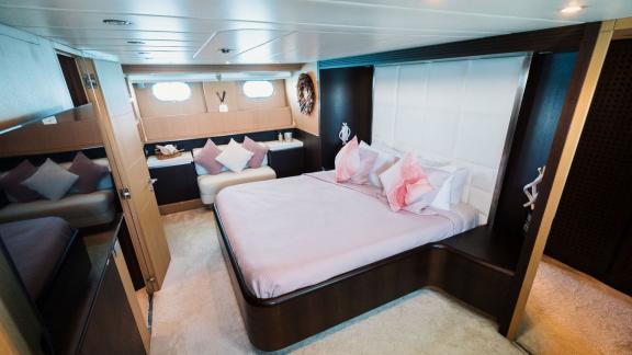 Among Ibiza weekly yacht charter options, Lady KC is seen with a master cabin featuring a large bed and lounge area.