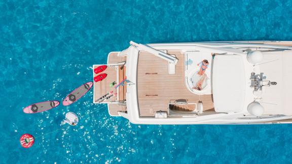 Among motor yacht rental options in Rhodes Lady Natassa is seen from above with sun area and water toys at sea.
