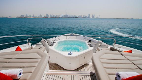 The sunbathing area with a jacuzzi on the Legende motor yacht adds comfort and luxury to your Dubai yacht rental experie