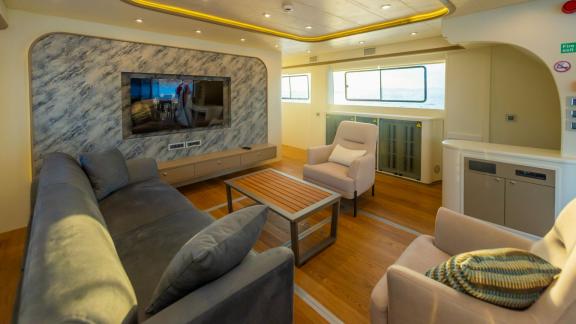 The modern salon of the luxury trawler Lycian Dream in Fethiye features comfortable seating and a large TV.