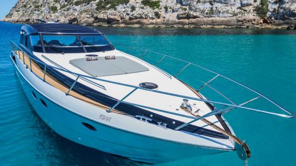 The foredeck of motor yacht Make My Day offers a relaxation area above turquoise waters.