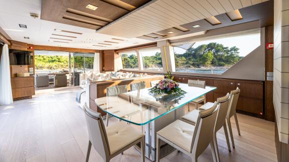 Der elegante Essbereich mit Glas­tisch bietet einen herrlichen Blick auf das Meer.