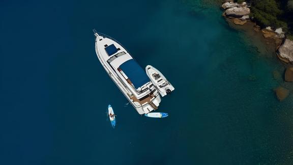 Die Motoryacht My Spica genießt eine Pause im tiefblauen Wasser, Draufsicht.