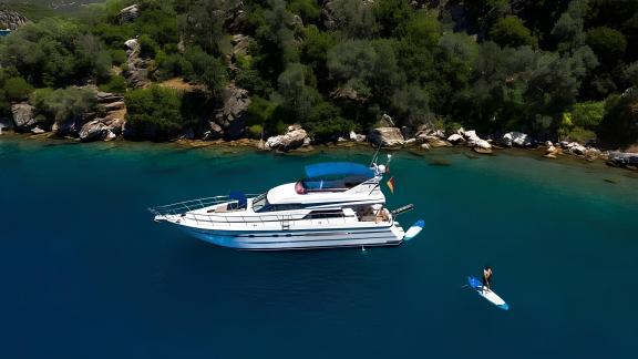 Die Motoryacht My Spica liegt vor Anker in einer ruhigen Bucht mit klarem Wasser.