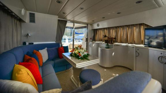 Im Salon der Motoryacht My Spica befindet sich eine komfortable Sitzecke mit bunten Kissen.