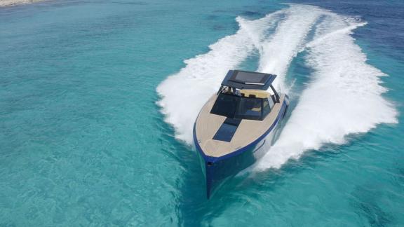 The Neve motor yacht leaves waves behind as it speeds across crystal-clear waters.