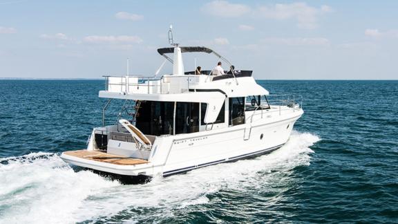 The motor yacht Ocean Dreamer cruising fast on the open sea, moving through the blue waters.