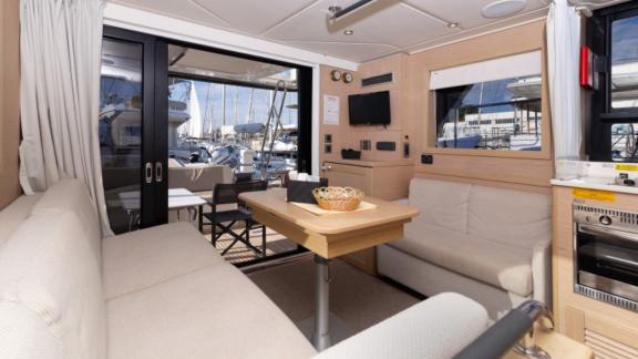 The interior of the motor yacht Ocean Dreamer in the harbor features a cozy seating area and a table.