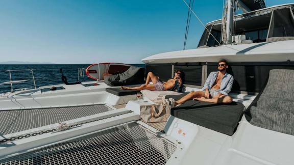 A couple is sunbathing comfortably on the deck of Oneida 2 catamaran.