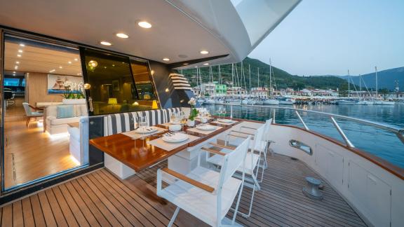 The stylish dining area on the aft deck of Opera yacht offers the perfect setting for an evening meal in the marina.