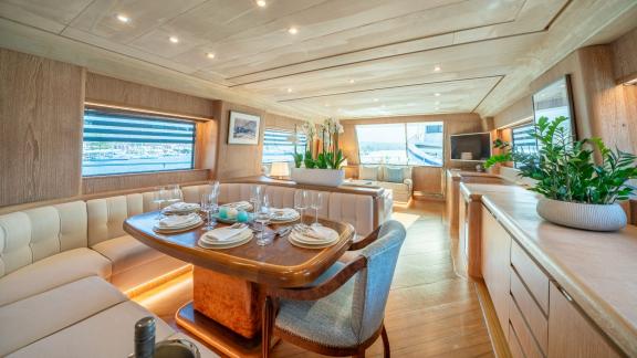 The elegant dining area of Opera yacht features a refined table setting with views through large windows.