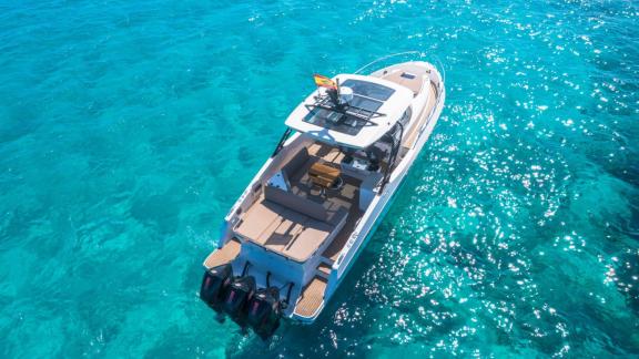 The rear of the Orix motor yacht gracefully floats over the clear blue waters.