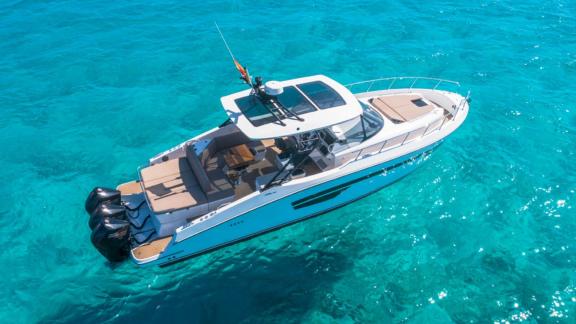 The Orix motor yacht in crystal-clear waters, showcasing elegant lines and modern design from a top-down perspective.