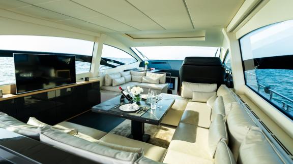 The comfortable and spacious saloon of Pershing 70 adds a touch of luxury to your Dubai yacht rental experience.