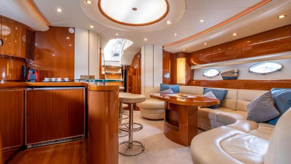 The main salon of Princess Juliet features a lounge area, dining table and onboard bar section.