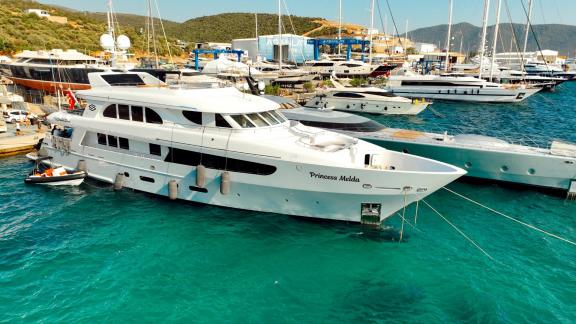 Motor yacht Princess Melda is anchored in the marina among other luxury yachts.