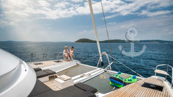 Two guests relaxing on the foredeck of the catamaran Princess S near Zadar, Croatia