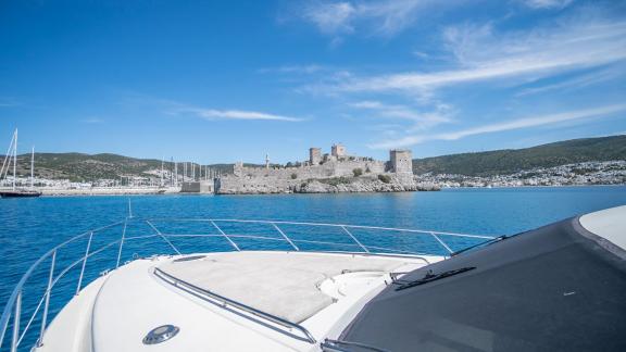 The motor yacht Queen anchored with a view of Bodrum Castle.