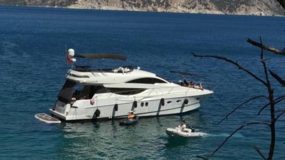 Motor yacht Rüzgar Demir is anchored near the shore.