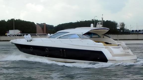 The motor yacht Sabijac cruising through the waves along the coastline.