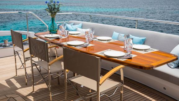 Tisch mit Gedeck und Polstern auf der Sea Story für Mahlzeiten bei Ibiza-Charter.