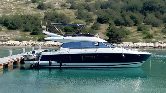 Die Motoryacht Serendipity I liegt im Hafen vor Anker, auf dem hinteren Deck befindet sich ein kleines Boot.