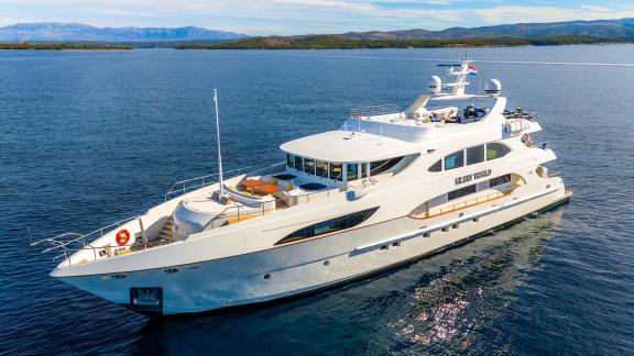 Die Motoryacht Silent World fährt vor Split Kroatien mit Blick auf Berge und Inseln.