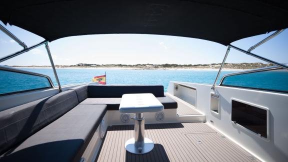 Elegant seating area with a small table on the aft deck of the Smart Ass motor yacht.