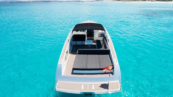 The Smart Ass motor yacht is seen from the rear, floating in turquoise waters.