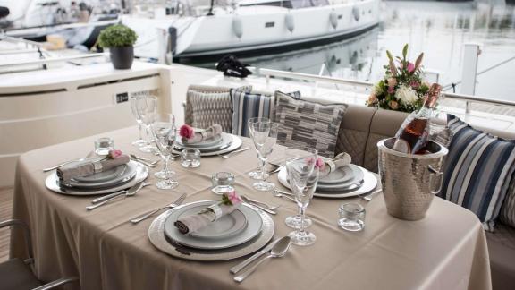 Among Athens yacht rental options Sofia D aft deck shows prepared dining table with elegant service.
