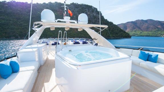 Das Deck der Yacht Stella Fiera mit Jacuzzi, verankert in einer malerischen Bucht.