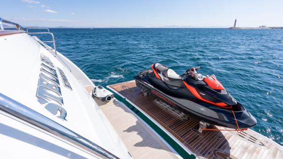 Jet-Ski-Bereich der Yacht Stella Fiera mit Blick auf das blaue Meer und einen entfernten Leuchtturm.